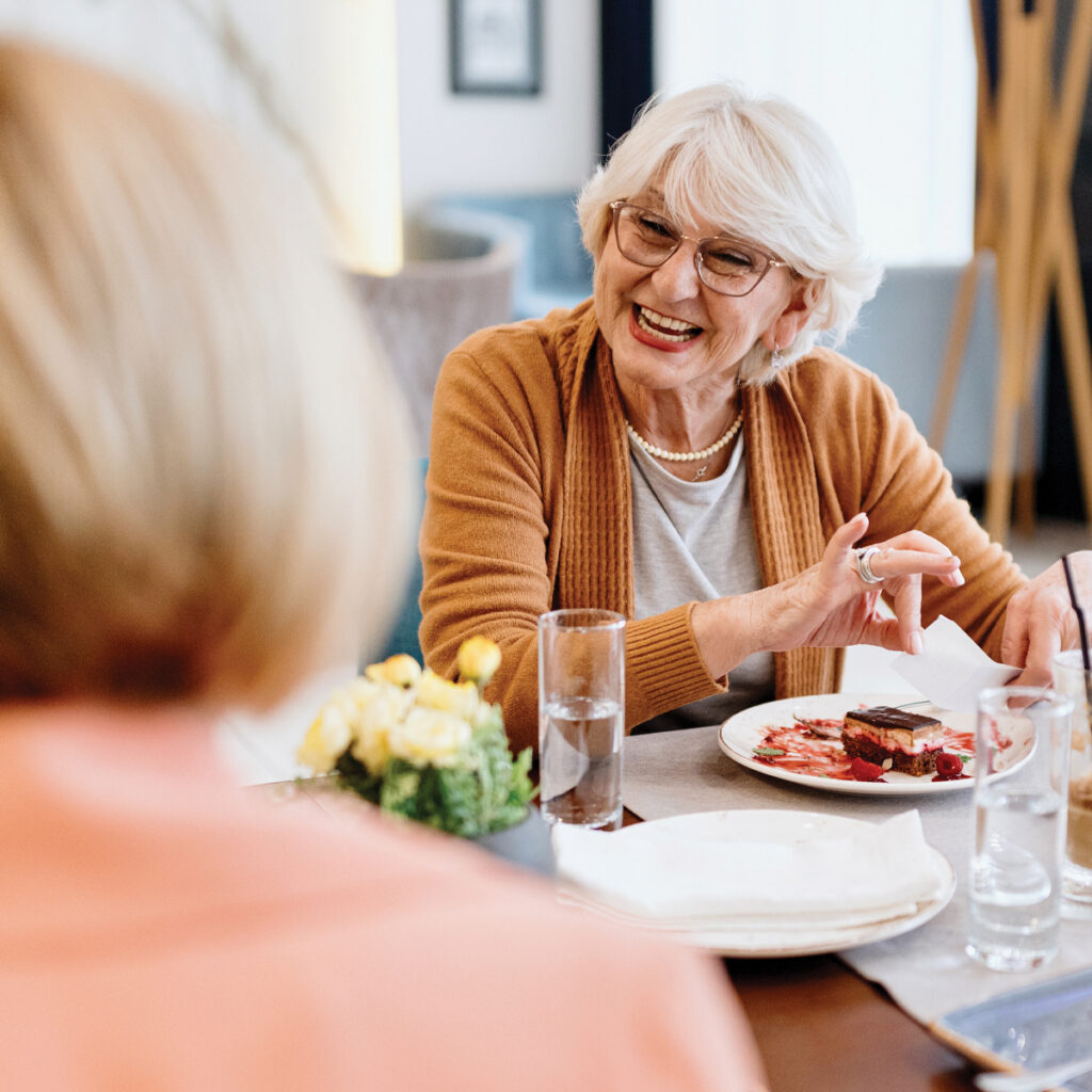 Two women talking over brunch and dessert